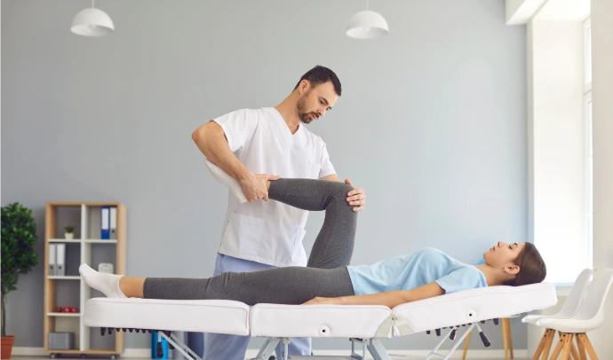 Ostéopathe travaillant avec un patient sur une table de traitement, démontrant les services d'ostéopathie en entreprise à la Clinique Ostéo Médica